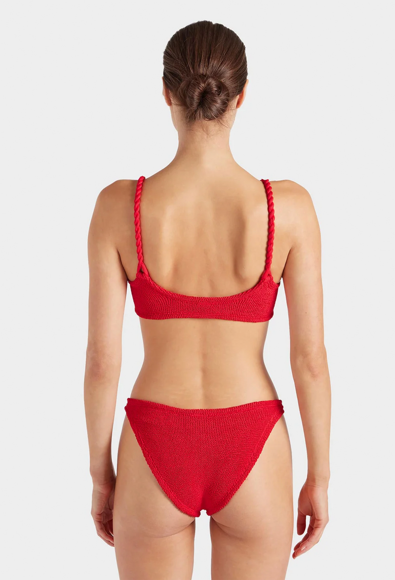 the back of a woman wearing a red bikini with crinkle fabric. white background.