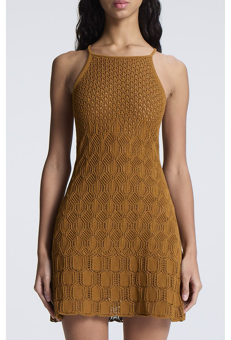 a woman wearing a golden brown high neck crocheted mini dress. white background.