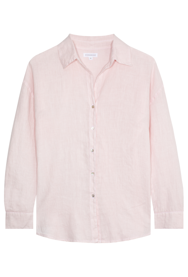 A FLATLAY OF A PINK LONG SLEEVE LINEN SHIRT WITH A COLLAR AND SHELL BUTTONS UP THE FRONT. THE FLATLAY IS UP AGAINST A TRANSPARENT BACKGROUND. 