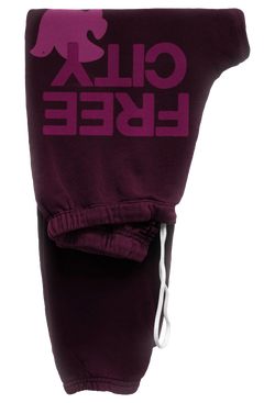 eggplant sweatpant with classic "FREECITY" print in magenta and tonal light pink "FREECITYDOVE," covered elastic waist and pull drawcord. transparent background
