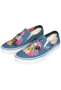 a pair of denim blue slip on vans with circular mulitcolored patterned patches of fabric stitched on. transparent background.