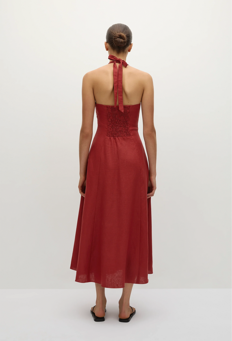 the back of a model wearing a red deep v halter neck midi dress. white background.
