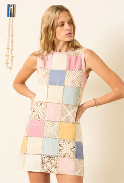 a model wearing a sleeveless multicolored pastel patchwork linen and crochet mini dress. white background