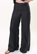a model wearing a pair of zip-up black pants. white background.
