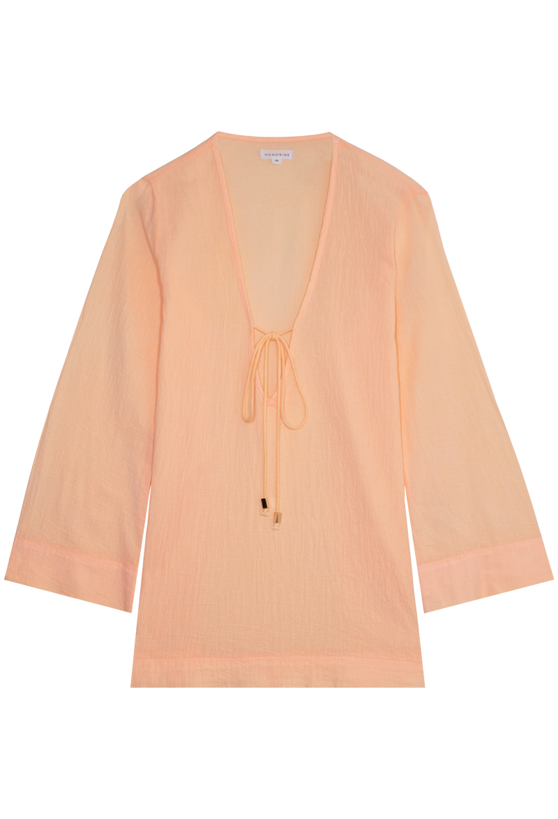 a melon colored deep v-neck mini coverup with long sleeves and a tie at the bust. transparent background.