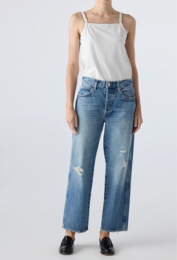 Person wearing a white tank top and blue jeans on a white background