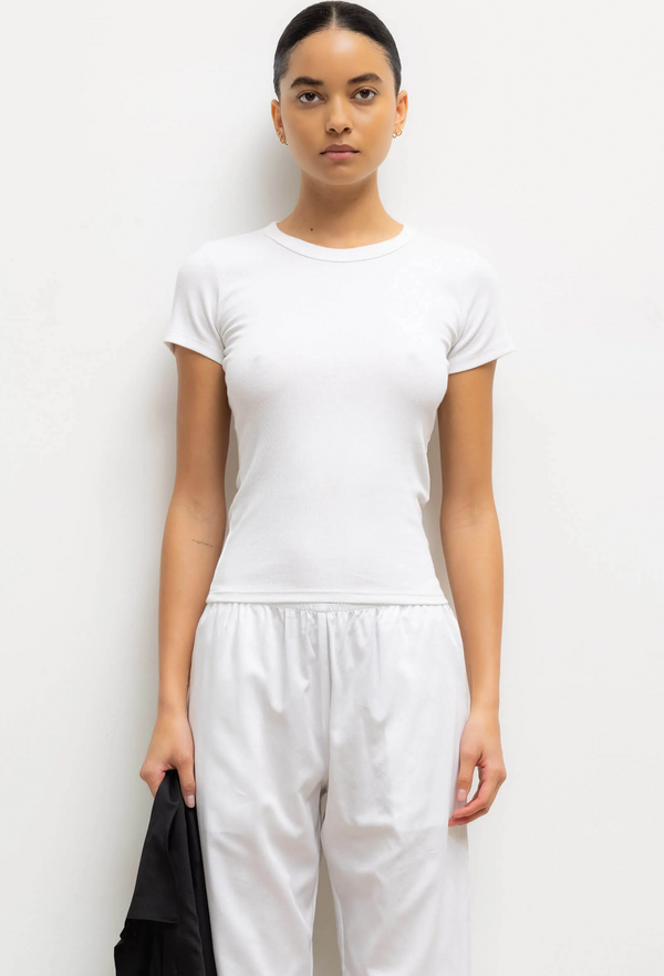 model wearing a fitted white t-shirt and pants against a white background