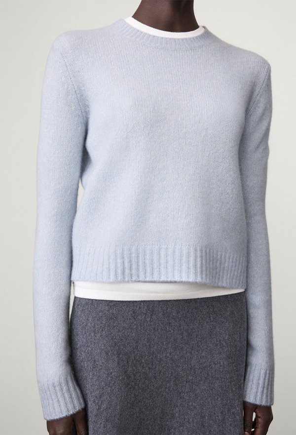 Light blue sweater worn by a model on a white background