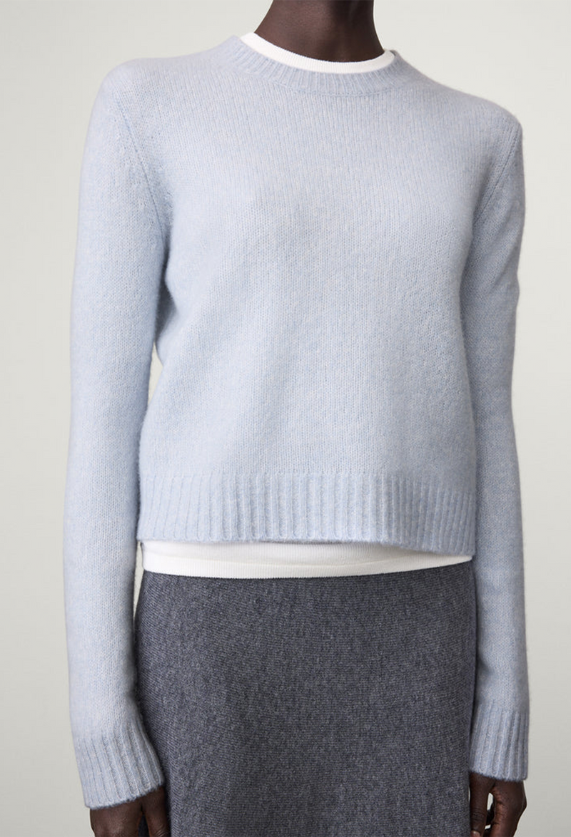 Light blue sweater worn by a model on a white background