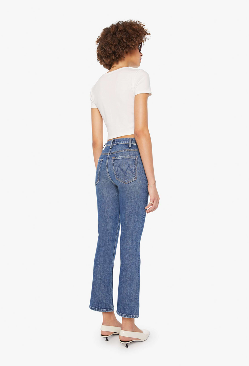 Woman wearing blue cropped jeans on a white background