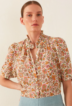 Woman wearing a floral blouse with a plain background