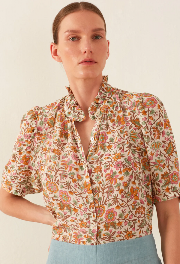 Woman wearing a floral blouse with a plain background