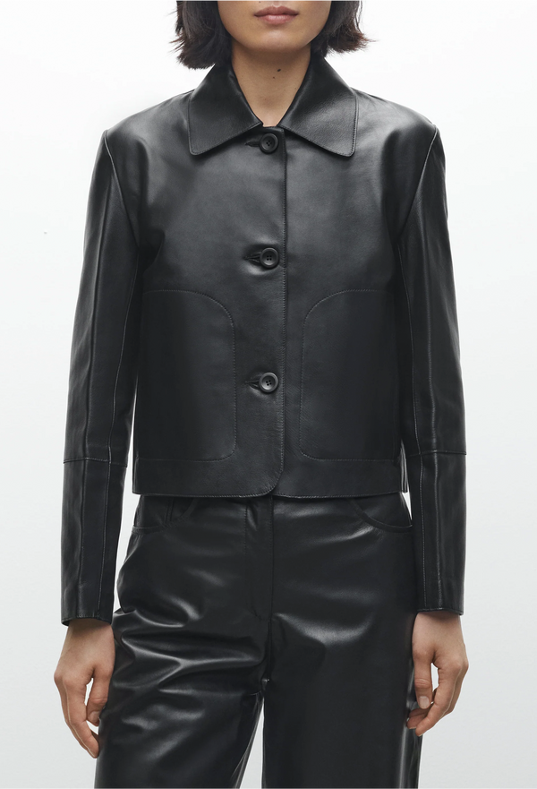 Black leather jacket worn by a person on a white background