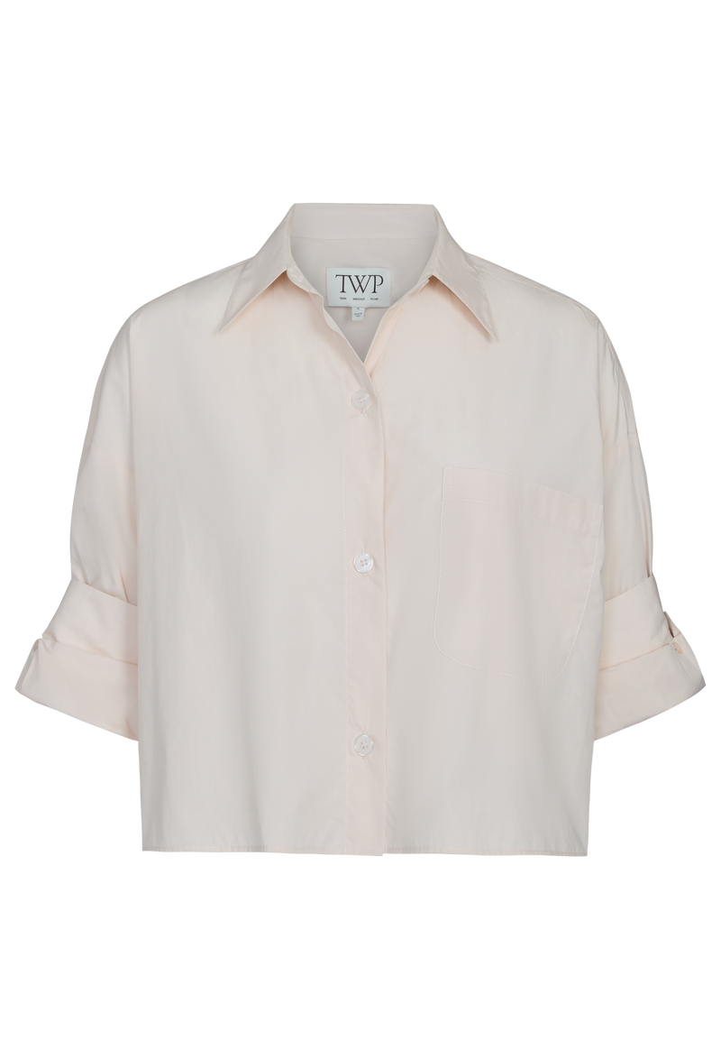 pale pink button down shirt on a white background