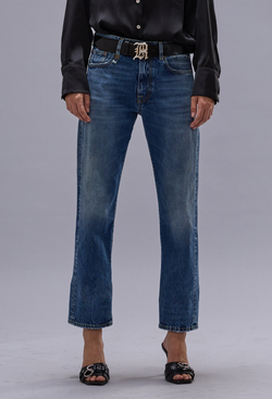 Person wearing blue jeans and a black leather jacket on a gray background