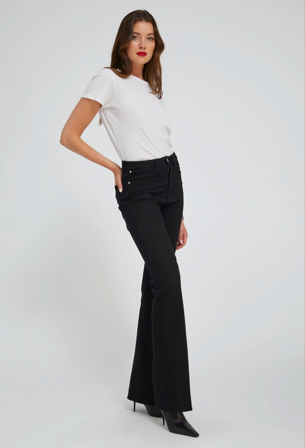 Woman wearing a white tee and black flared jeans on a white background