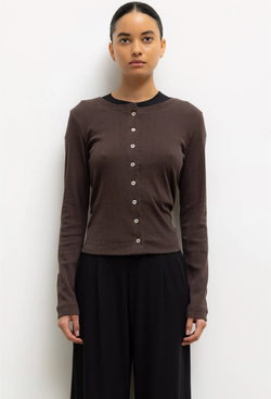 Woman wearing a brown cardigan with buttons against a white background