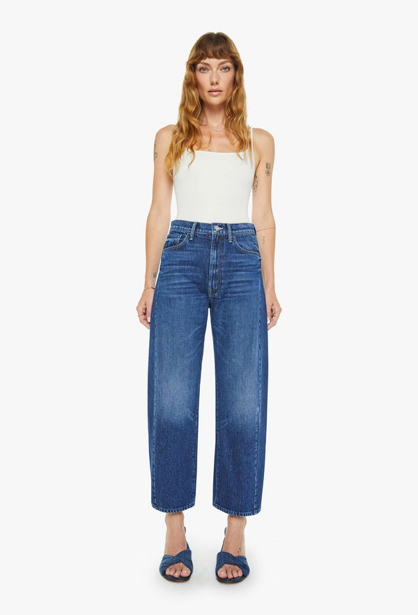 Woman wearing a white top and blue jeans on a white background