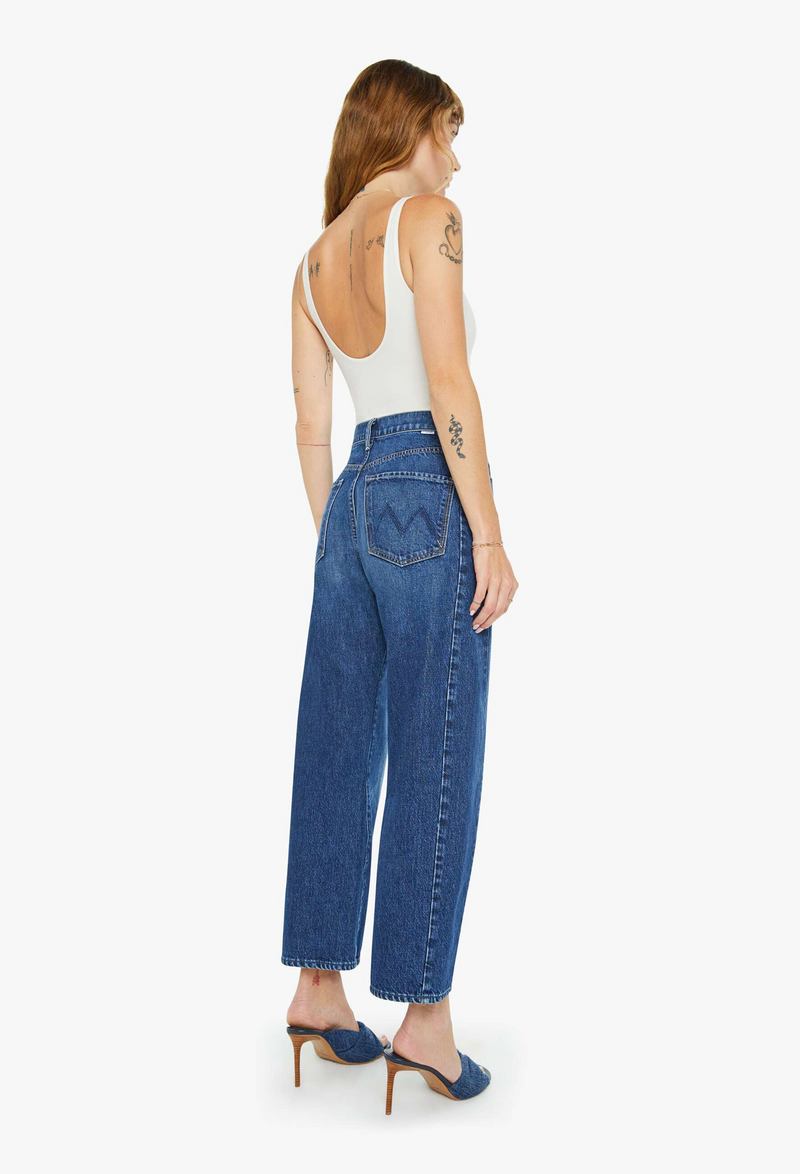 Woman wearing blue jeans and a white top on a white background
