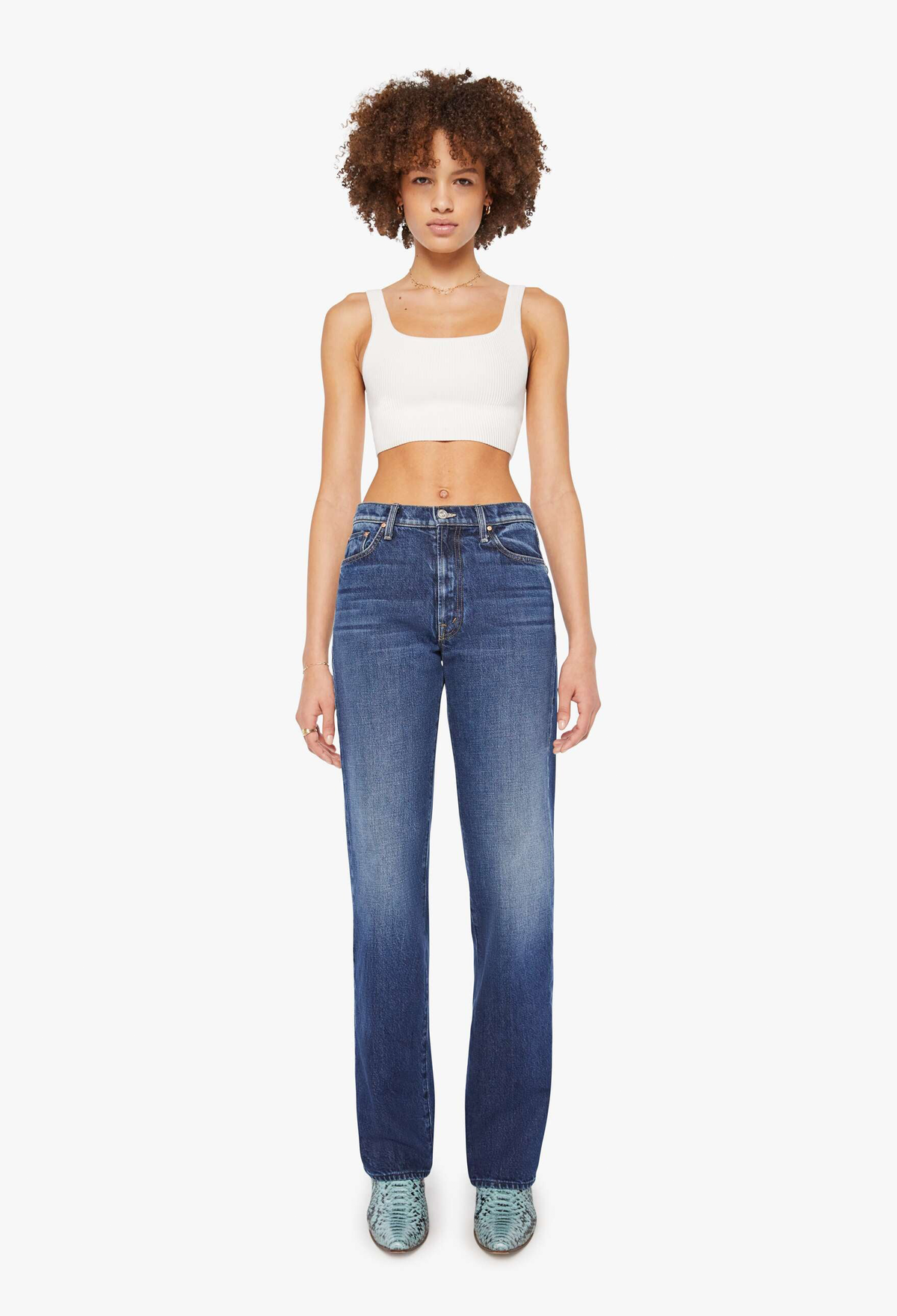 Woman wearing blue jeans and a white top on a white background