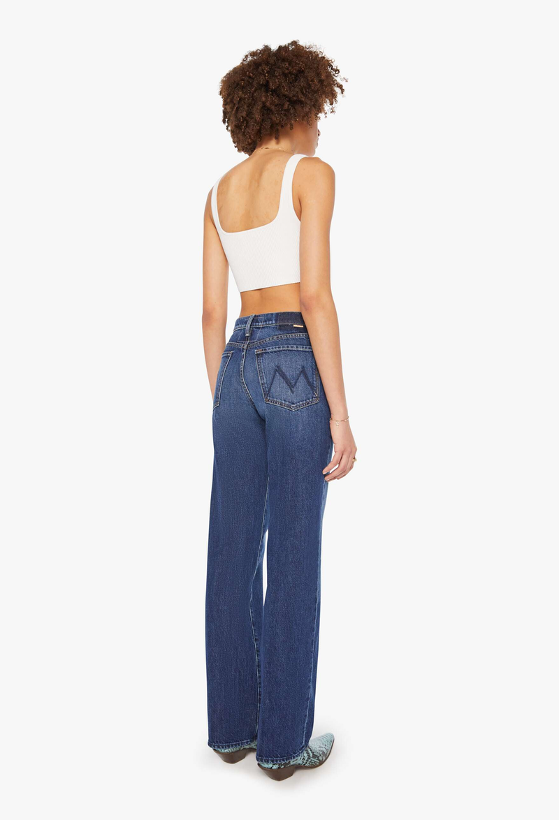 Woman wearing blue jeans and a white top on a white background