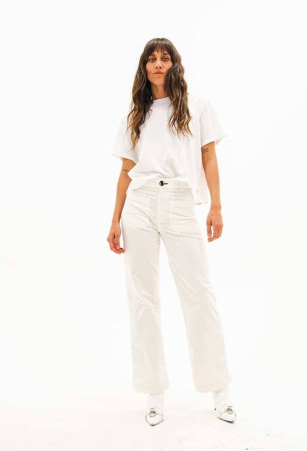 Person wearing a white t-shirt and cream-colored pants on a white background