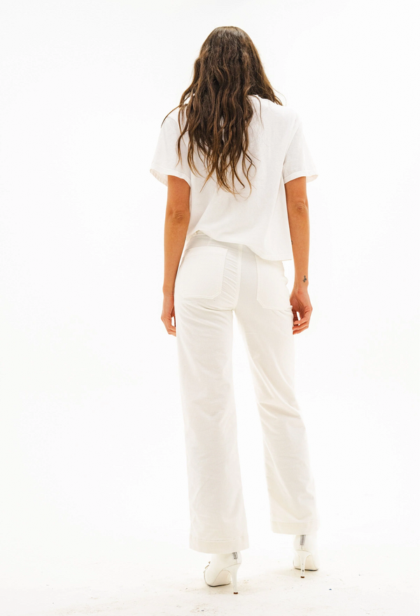 Person wearing a white t-shirt and off white pants on a white background