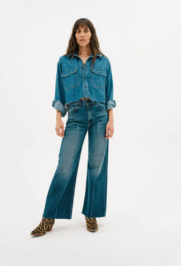 Woman wearing a denim shirt and jeans on a white background