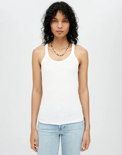 MODEL WEARING THE RE/DONE RIBBED TANK TOP WITH A MULTICOLORED BEADED NECKLACE AND LIGHT WASH JEANS. MODEL IS UP AGAINST A LIGHT GREY BACKGROUND