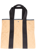 Tan quilted tote bag with two black straps, set against a checkered background. 