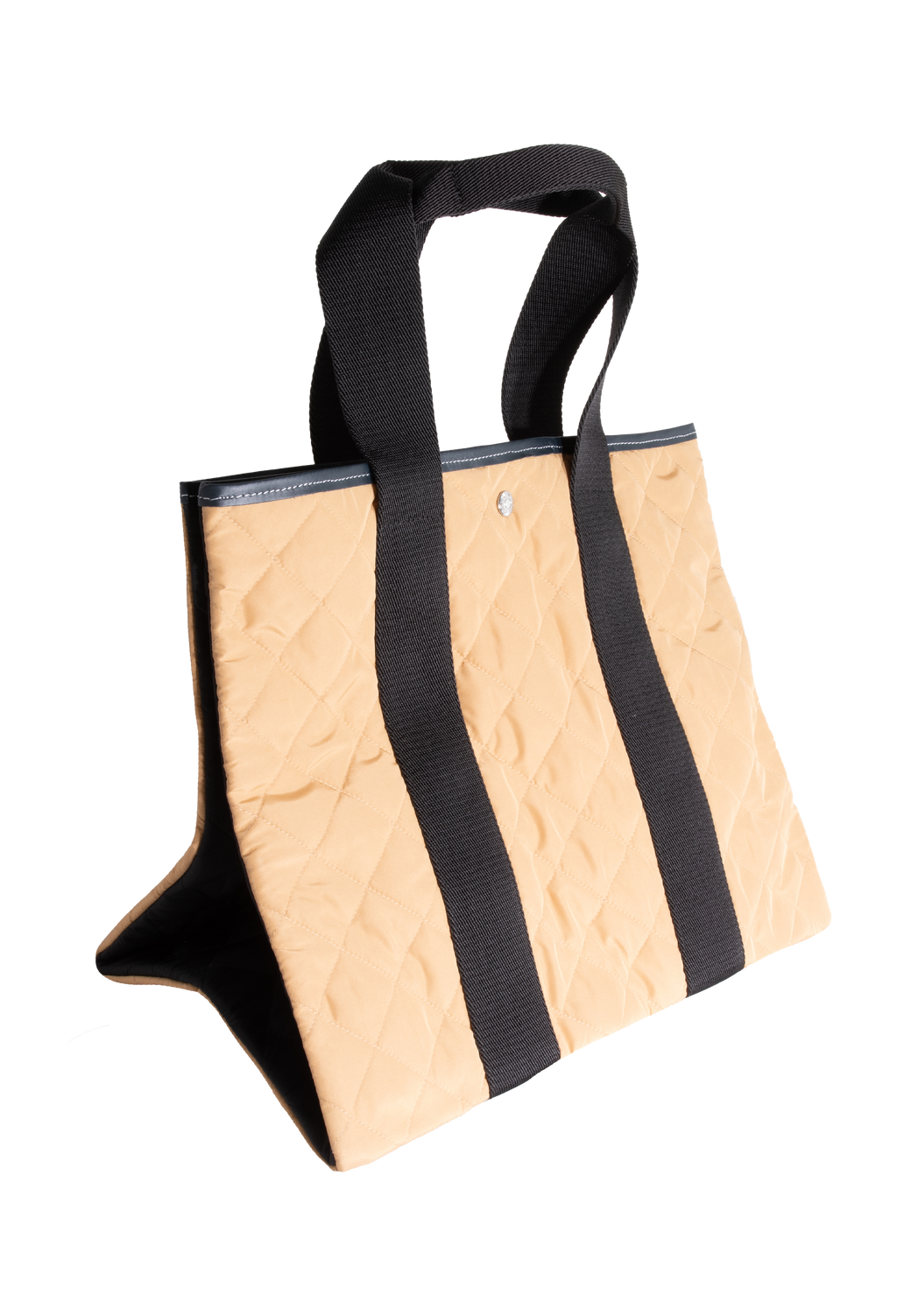 Tan quilted tote bag with two black straps. Set against a checkered background. 