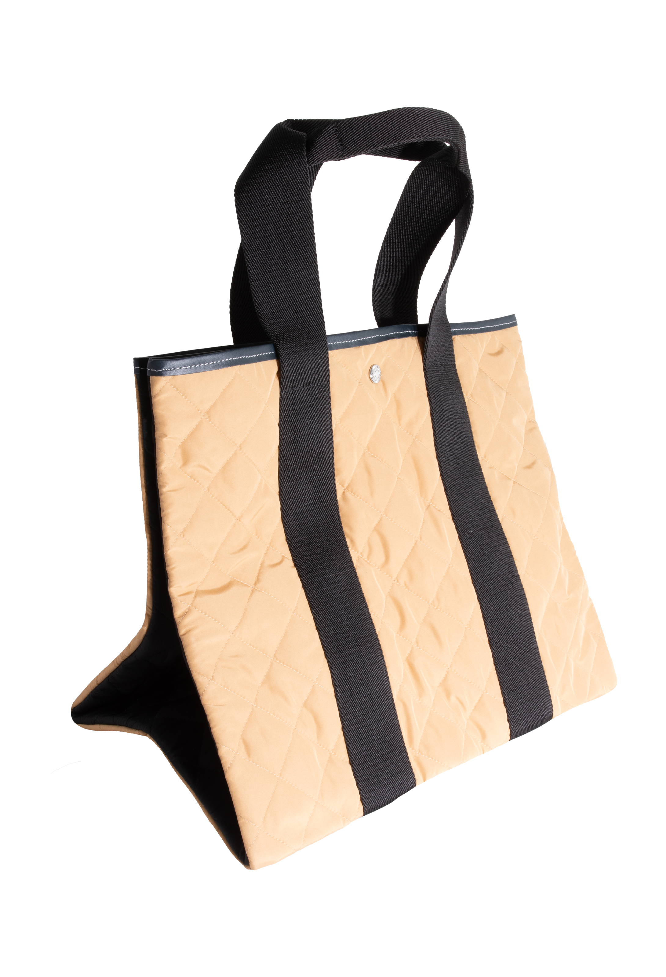 Tan quilted tote bag with two black straps. Set against a checkered background. 