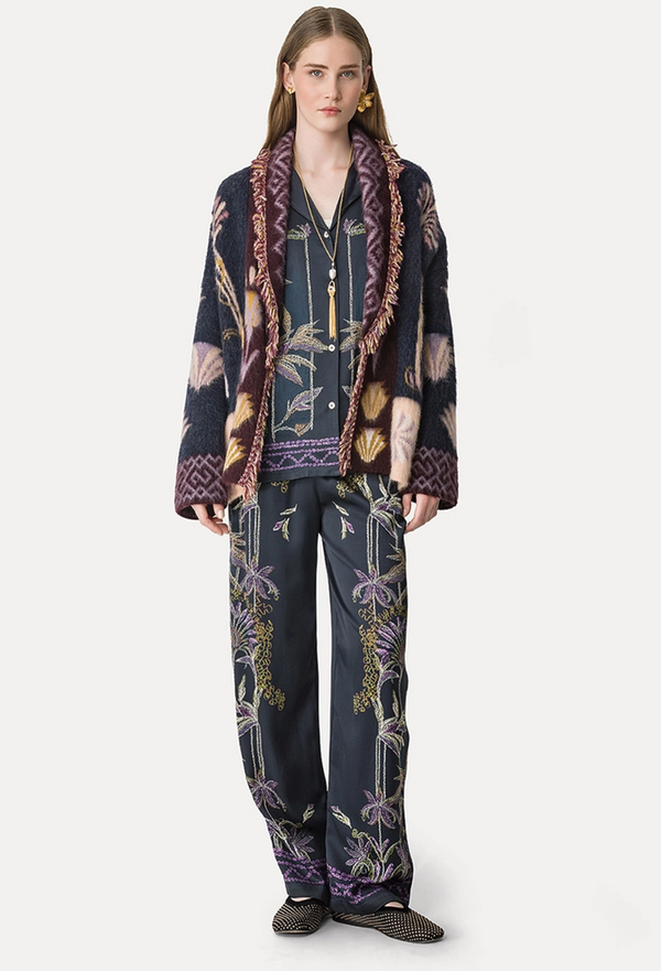 Person wearing a patterned outfit with a jacket and pants on a white background