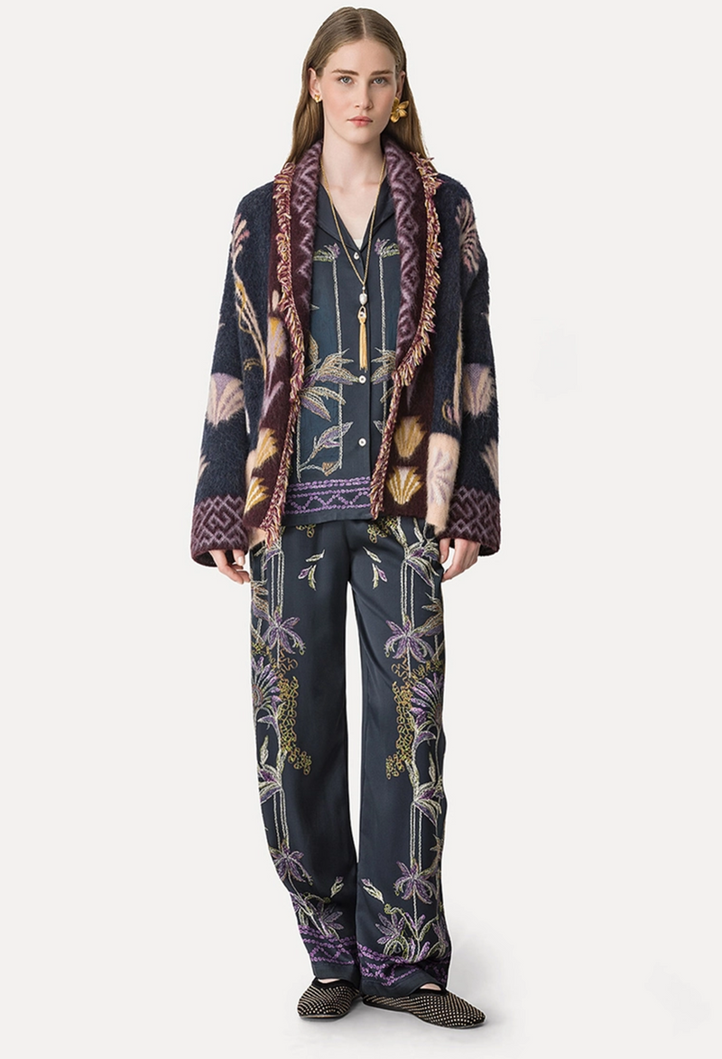 Person wearing a patterned outfit with a jacket and pants on a white background