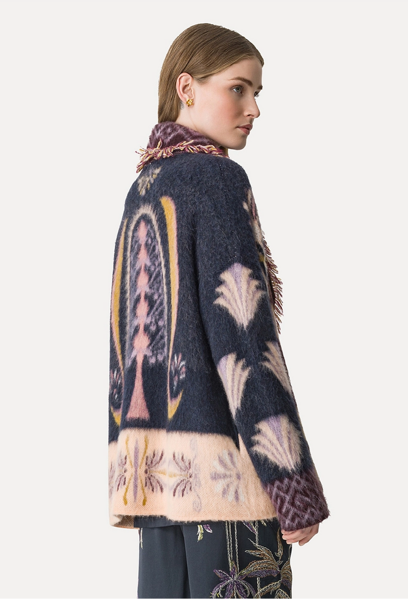 Woman wearing a patterned cardigan with a white background