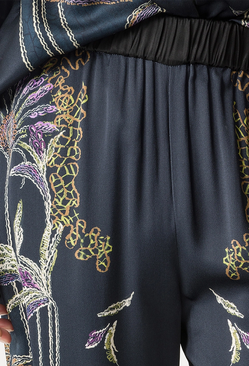 Navy blue fabric with intricate gold and green floral embroidery on a plain background
