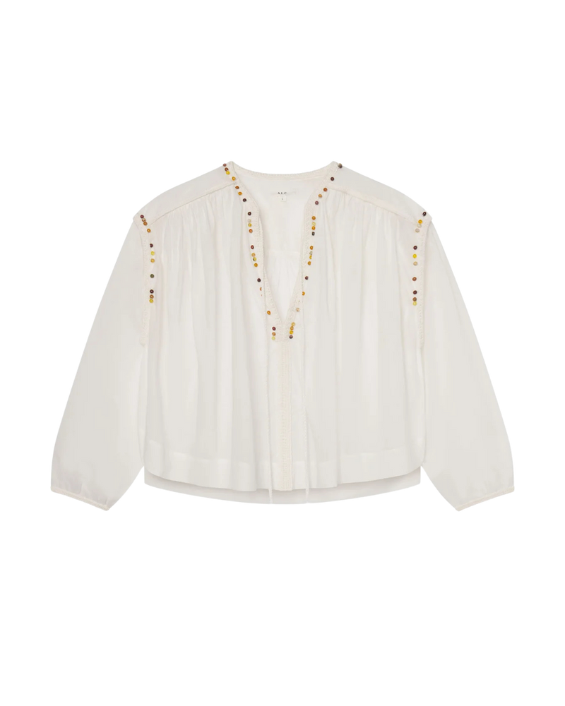 A FLATLAY OF THE WHITE JODIE TOP. THE BEADING IS ON THE NECKLINE AND SHOULDER LINE. THE PHOTO IS ON A TRANSPARENT BACKGROUND