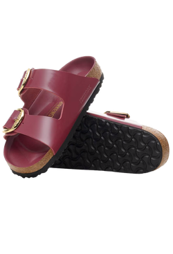 Red sandal with gold buckles on a white background