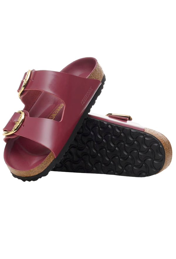 Red sandal with gold buckles on a white background