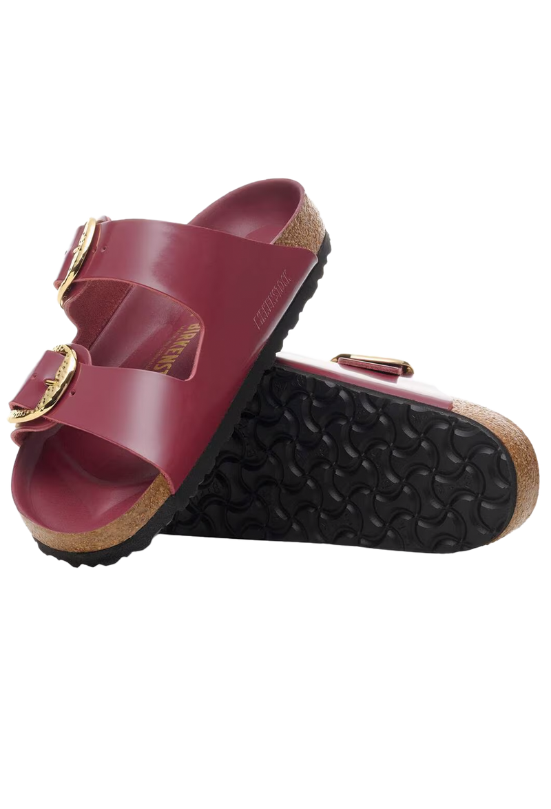 Red sandal with gold buckles on a white background